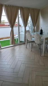 a living room with a wooden floor and a table and chairs at Happy House in Marina di Cerveteri