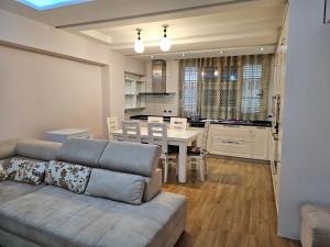 ein Wohnzimmer mit einem Sofa und einem Esszimmer in der Unterkunft Tirana Central Exclusive in Tirana