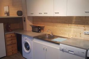 a kitchen with a sink and a washing machine at Chalet avec terrasse face aux Pyrénées in Bartrés
