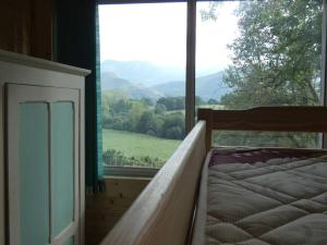 a bedroom with a bed and a large window at Chalet avec terrasse face aux Pyrénées in Bartrés +6 photos