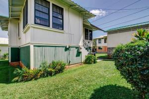 a house with a green fence next to a yard at NEW Paddler's Inn- 3BR Hilo Downtown in Hilo