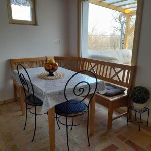 uma sala de jantar com uma mesa com uma taça de fruta em Recece vendégház em Gyepükaján