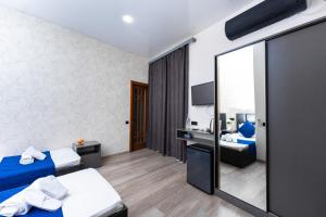 a hotel room with two beds and a mirror at Bloom Hotel Yerevan in Yerevan