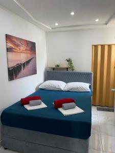 a bedroom with a blue bed with two pillows on it at Apartments and Rooms Pavla in Senj