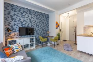 un soggiorno con divano e TV a parete di ALLEE BUDA Apartment a Budapest