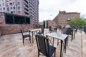 a row of tables and chairs on a roof at Bloom Hotel Yerevan in Yerevan