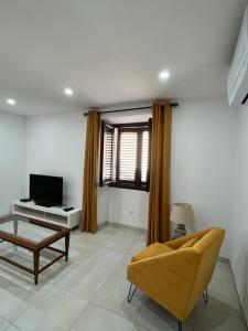 Una sala de estar con un sofá y un televisor. en A COLETTA, en Piana