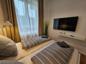 a hotel room with two beds and a flat screen tv at Central City White Line in Kiel