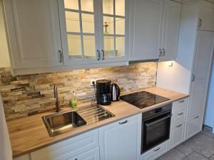 a kitchen with white cabinets and a sink at Central City White Line in Kiel
