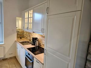 a kitchen with white cabinets and a coffee maker on the counter at Central City White Line in Kiel