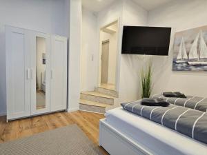 a bedroom with a bed with a flat screen tv on the wall at Central City White Line in Kiel +21 photos