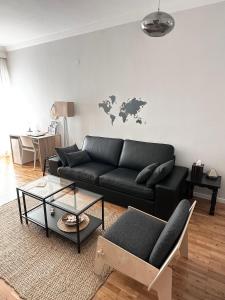 una sala de estar con un sofá negro y un mapa en la pared en Spacious 82 m2 Two Bedroom classy apartment near City Center, en Tesalónica