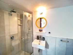 a bathroom with a sink and a shower and a mirror at Pefkakia Park in Ermoupoli