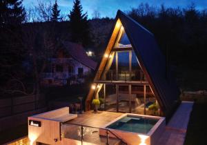 a small house with a swimming pool in the night at V house Goc in Miodragoviči