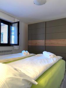 Apartments Giana في لابين: غرفة نوم بسريرين عليها مناشف