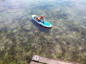 a person laying on a paddle board in the water at Bahia Coral Lodge in Bocas del Toro