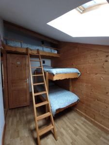 a bunk bed in a room with a ladder at 7 p - Au cœur du massif jurassien in Les Rousses