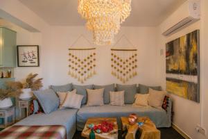 a living room with a blue couch and a chandelier at Akamas Sunset Boho Chic Maisonette by ONE VILLAS in Polis Chrysochous