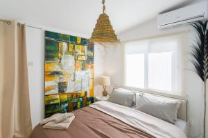 Schlafzimmer mit einem Bett mit Wandgemälde in der Unterkunft Akamas Sunset Boho Chic Maisonette by ONE VILLAS in Polis Chrysochous