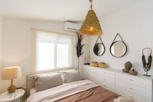 a bedroom with a bed and a window at Akamas Sunset Boho Chic Maisonette by ONE VILLAS in Polis Chrysochous