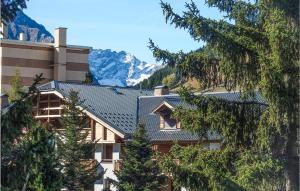 a house with a roof with mountains in the background at Nice Apartment In Vnosc With 1 Bedrooms in Vénosc