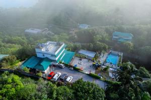 an aerial view of a house with cars parked in front at Treehouse Tabor Hills Resort Vagamon in Vagamon