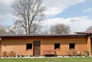 a wooden cabin with a table and chairs in front of it at Sołtysówka in Wólka Nadbużna
