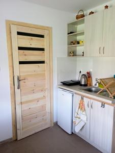 uma cozinha com uma porta, um lavatório e um balcão em Sołtysówka em Wólka Nadbużna