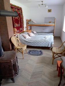 a small bedroom with a bed and two chairs at Sołtysówka in Wólka Nadbużna
