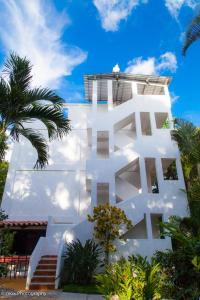 a white building with a palm tree in front of it at Hotel Ciudad Blanca in Copán Ruinas