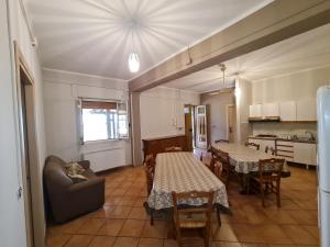 een woonkamer met 2 tafels en een keuken bij Zio Mario e Zia Maria - Casa Vacanze e Affitti brevi in Castrovillari