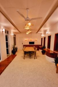 a living room with a table and a ceiling fan at Vaagali Inn in Keyodhoo