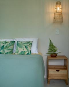a bedroom with a bed and a plant on a night stand at Casa Alba - Portasol Vacation in Savegre