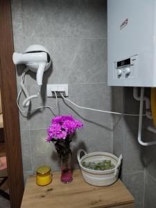 un telefono e un vaso di fiori su un tavolo di Apartman 007 a Kragujevac