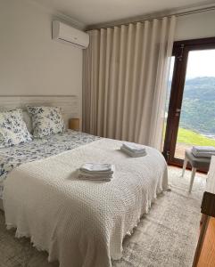 a bedroom with a bed with towels on it at Casa Catita - Douro in Baião