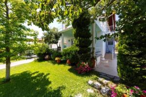 a yard of a house with plants and flowers at Villa Mary in Nea Kallikrateia