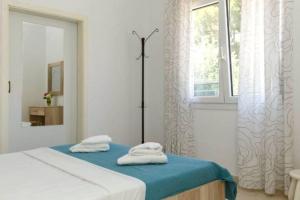 a bedroom with a bed with two towels on it at Villa Mary in Nea Kalikratia