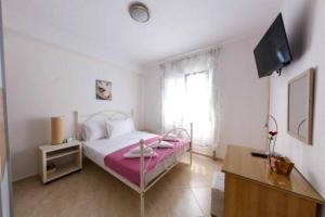 a bedroom with a bed and a television in it at Villa Mary in Nea Kalikratia