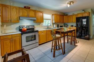 a kitchen with wooden cabinets and a table with chairs at Charlotte Vacation Rental with Private Hot Tub! in Matthews