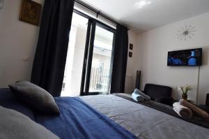 ein Schlafzimmer mit einem Bett und einem großen Fenster in der Unterkunft Tayson Square Dorcol New Location free garage in Belgrad