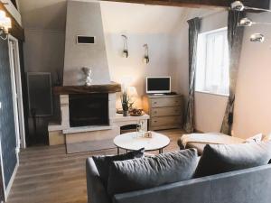 ein Wohnzimmer mit einem Sofa und einem Kamin in der Unterkunft Domaine Pont Juillet in Fontaines