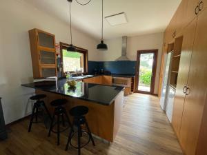 a kitchen with a black counter top and stools at Casa Catita - Douro in Baião