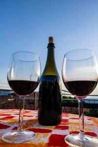dos copas de vino en una mesa con una botella de vino en Casa Soleggiata, en Mazzola