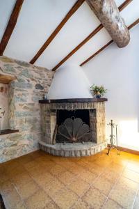 a living room with a stone fireplace in a attic at Casa Soleggiata in Mazzola +3 photos
