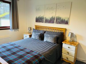 a bedroom with a bed with two night stands and two lamps at River house in Birnam