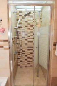 a shower with a glass door in a bathroom at Eleni's Σπίτι μπροστά στη θάλασσα in Daratso