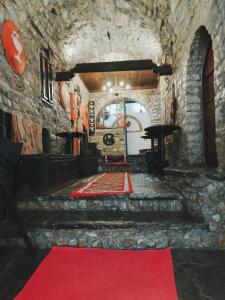 a red carpet in a room with a stone wall at Guva Mangalem Hotel Restaurant in Berat