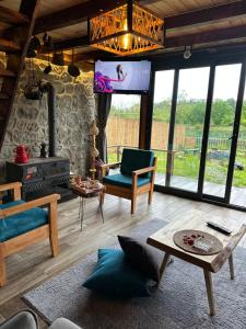 a living room with a fireplace and a tv at Panpubungalov in Pazar