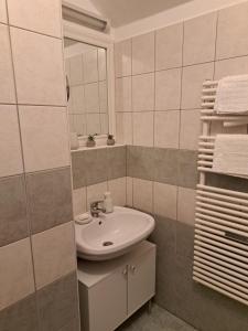 a bathroom with a sink and a mirror at Rózsa Apartman Keszthely in Keszthely