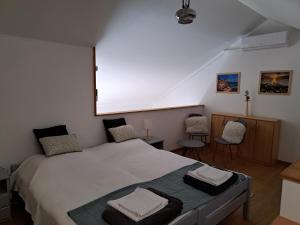 a bedroom with a large bed with two chairs at Rózsa Apartman Keszthely in Keszthely